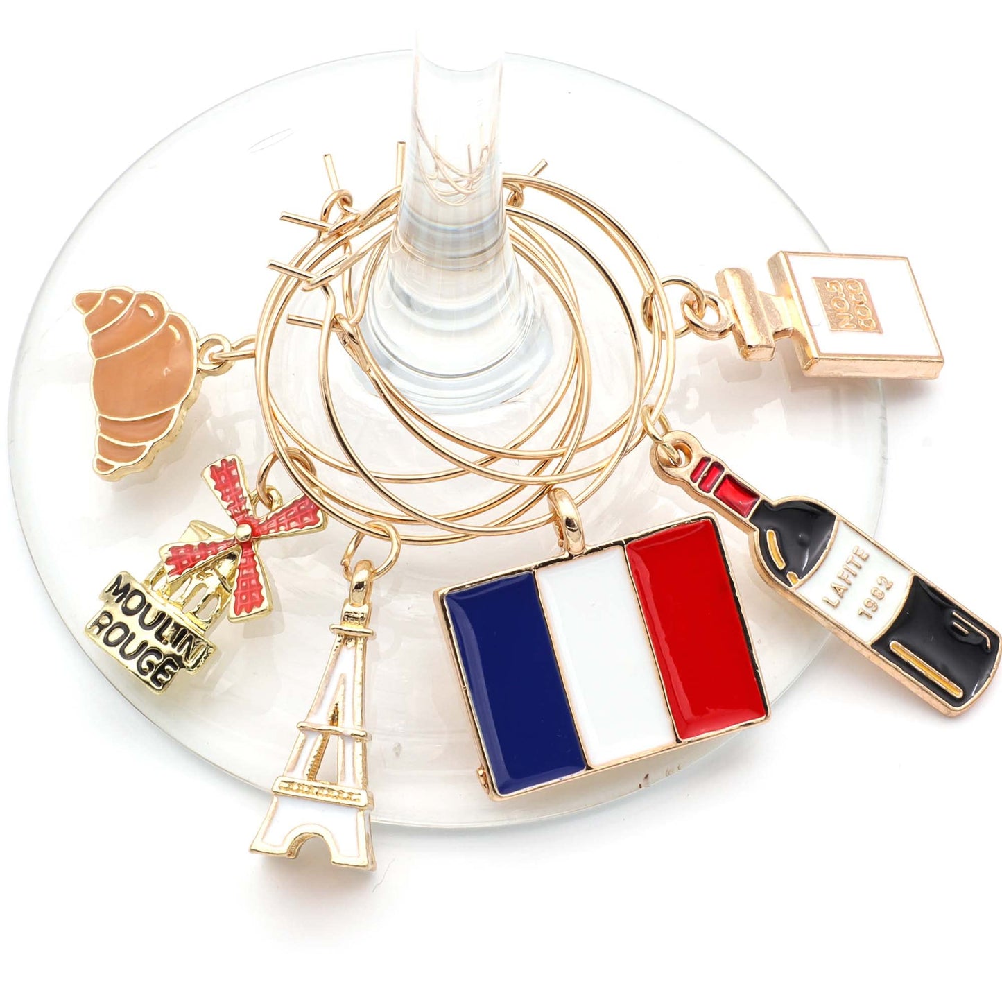A set of French Wine Charms including the Flag of France, Eiffel Tower, Crossaint, Moulin Rouge, French Wine and Perfume hooked on the glass.