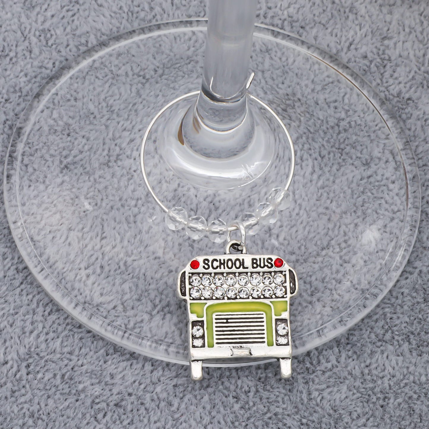 A Favorite Teacher Wine Glass Charms hooked on the glass.