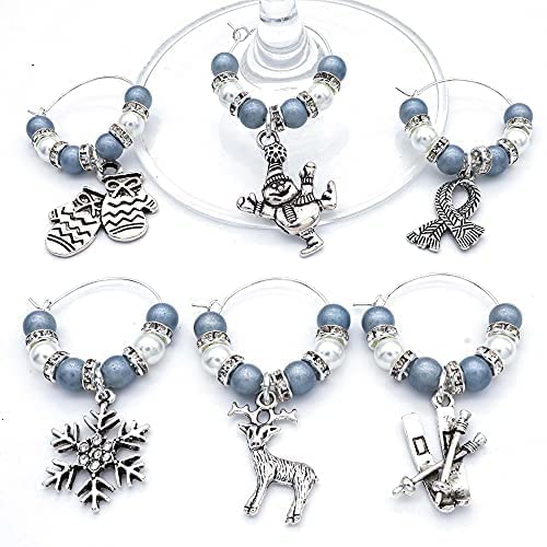 Christmas Wine Glass Charms, Set of 6, Charms Include: Snowman, Ski, Mitttens, Shawl, Snowflake, Deer on a gray surface