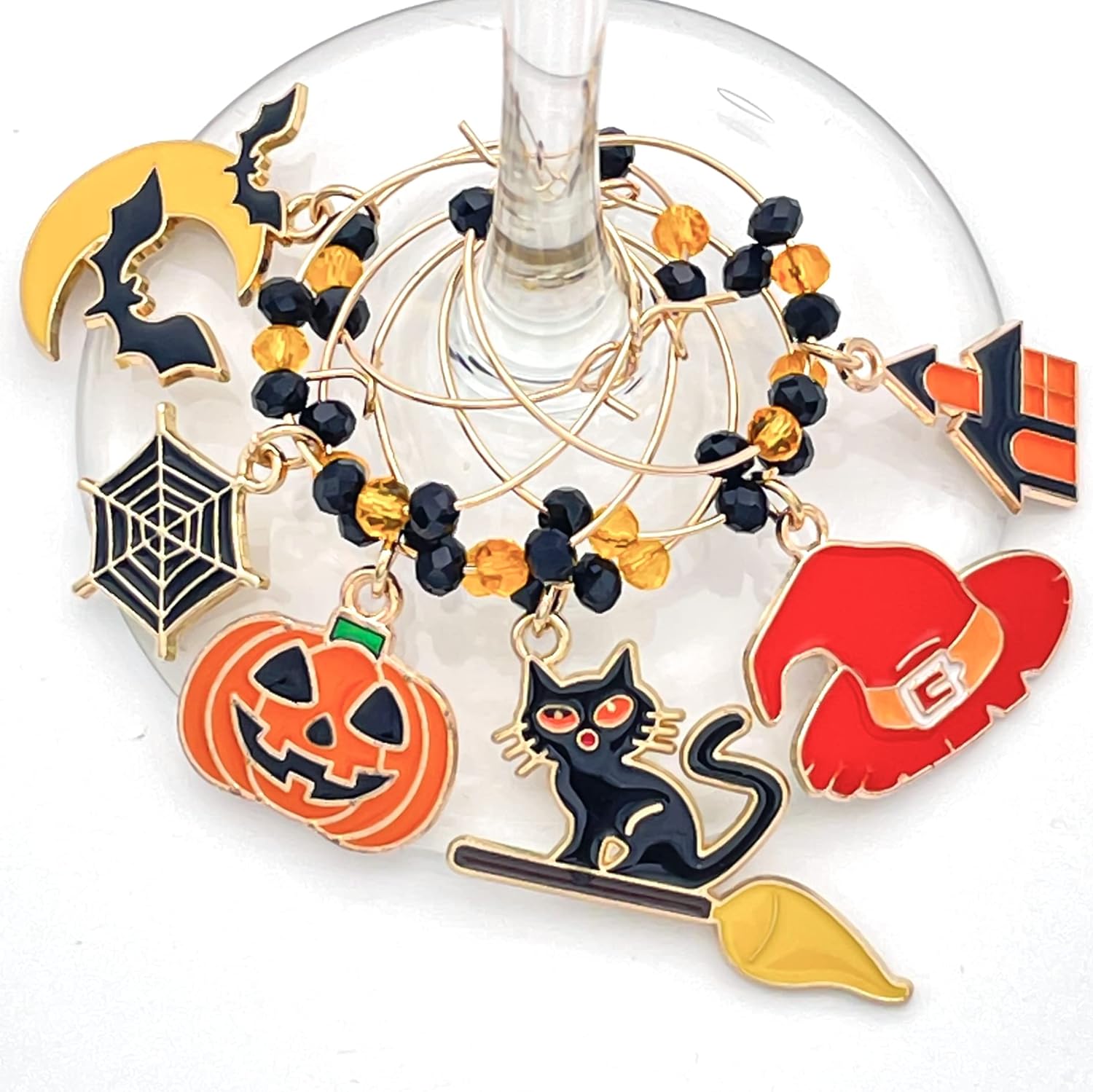 Halloween Wine Charms set of witch hat, bat, spider web, jack-o'-lanterns, and black cat hooked on the glass.