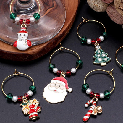 A set of Christmas Wine Charms on a black surface.