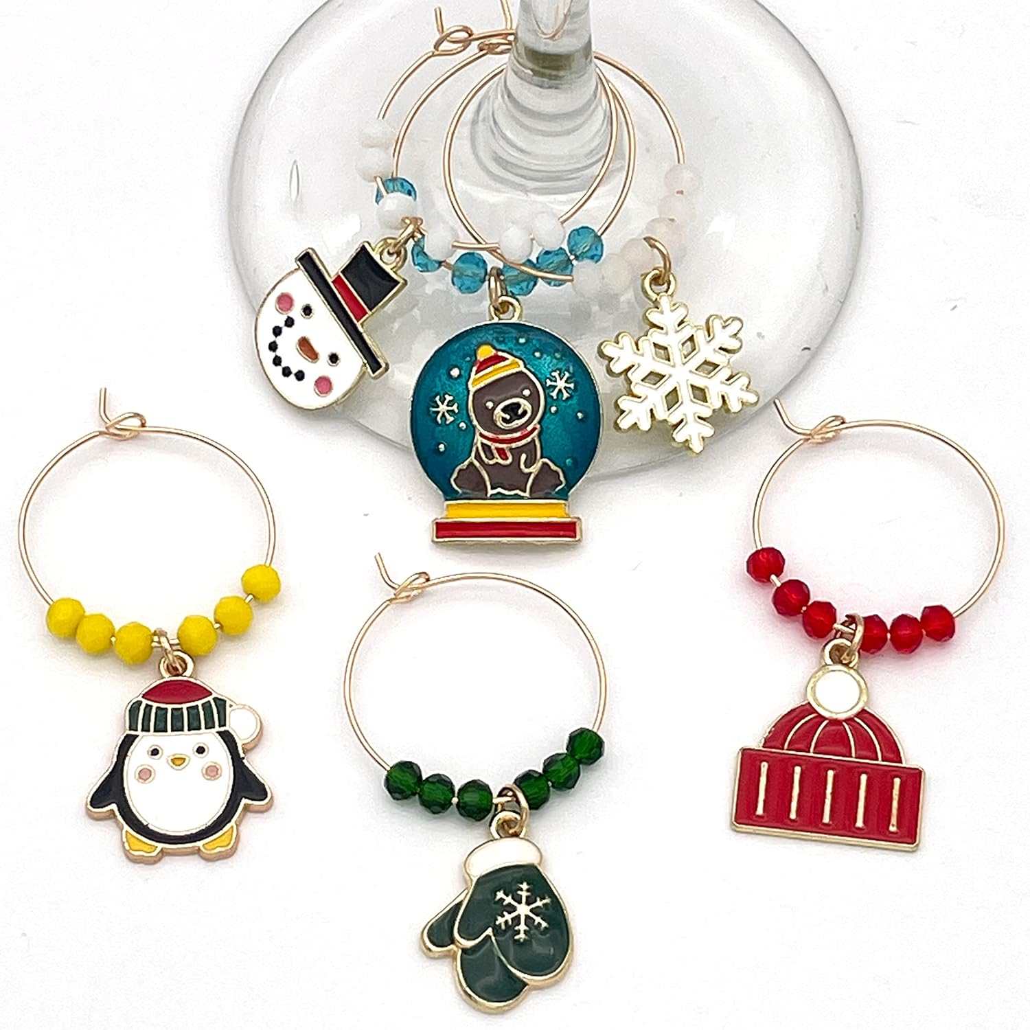 A set of Six Winter Wine Glass Charms hooked on the glass.