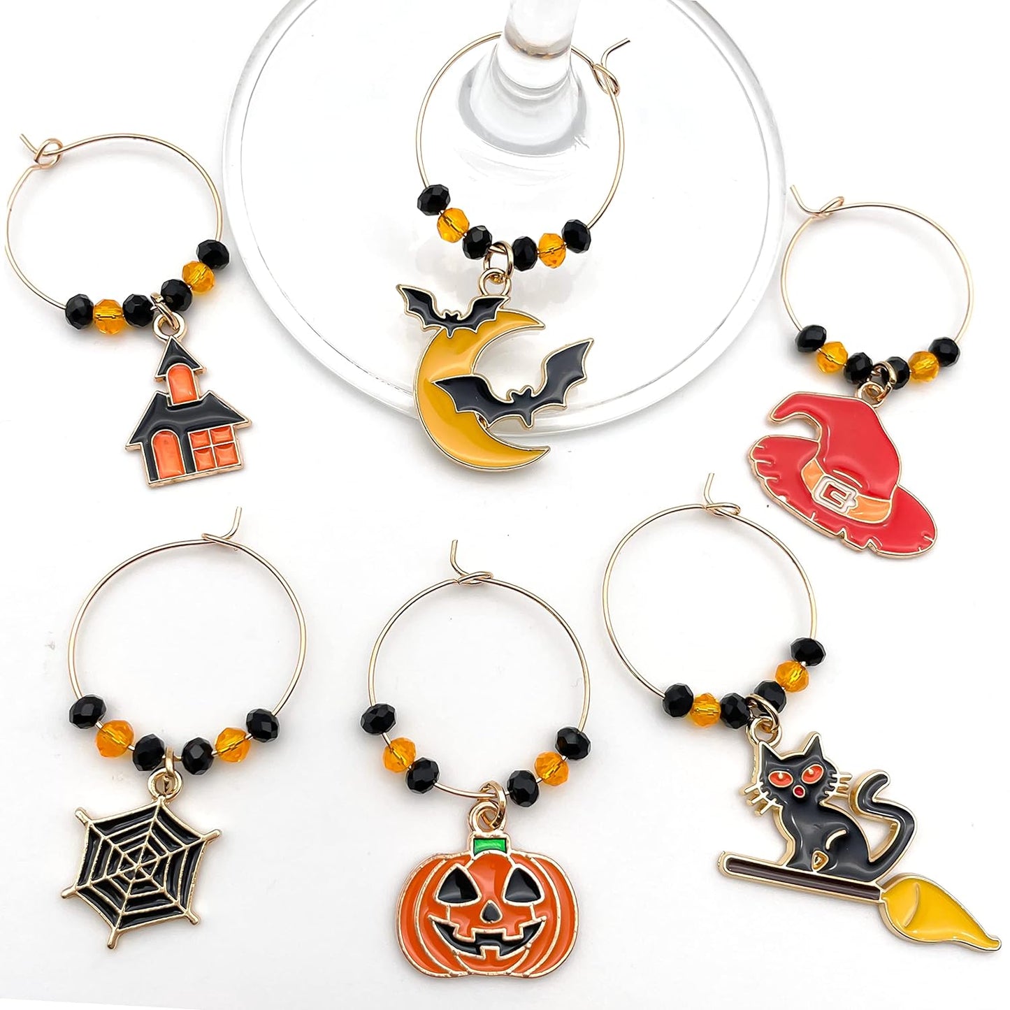 Halloween Wine Charms set of witch hat, bat, spider web, jack-o'-lanterns, and black cat on a white surface.