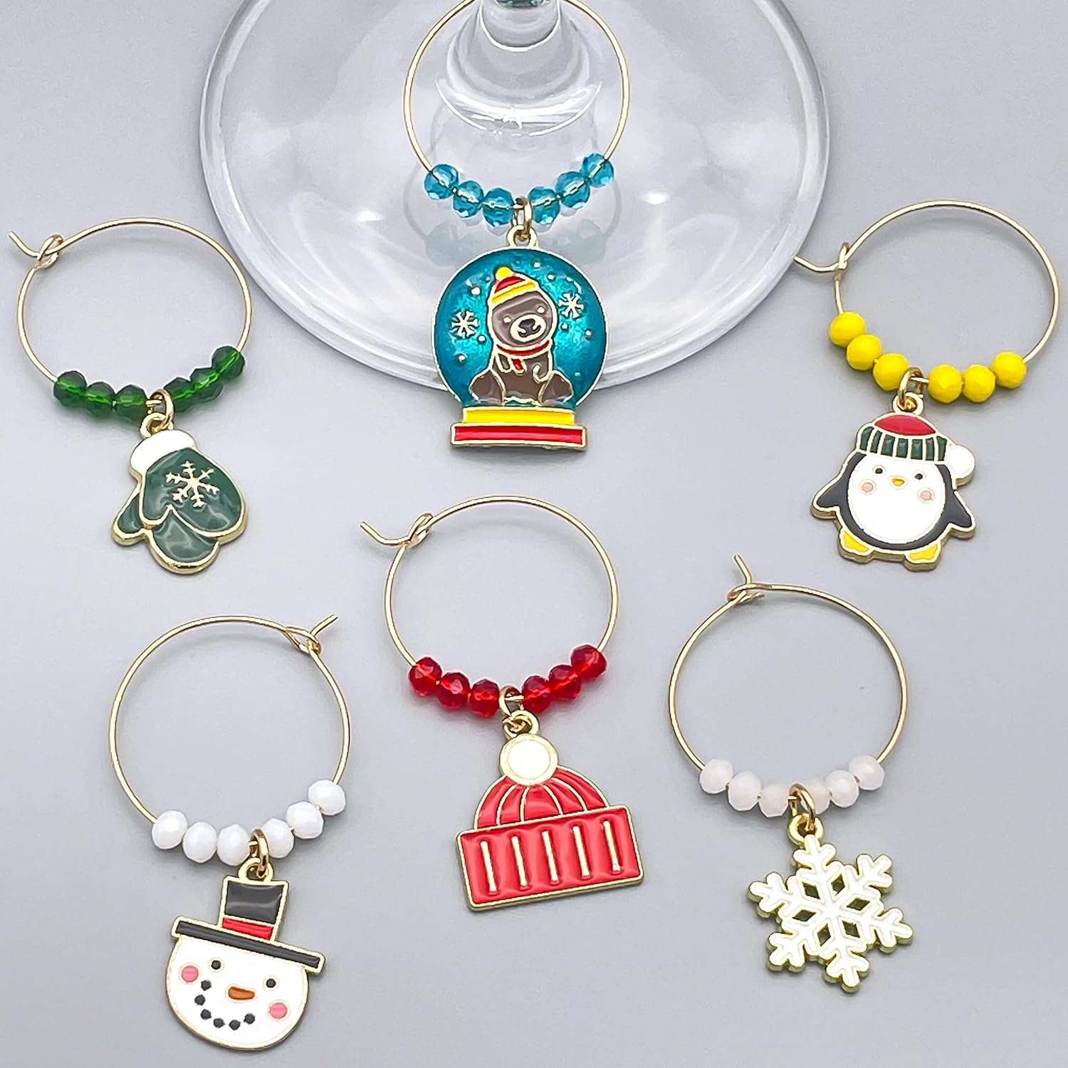 A set of Six Winter Wine Glass Charms hooked on the glass.