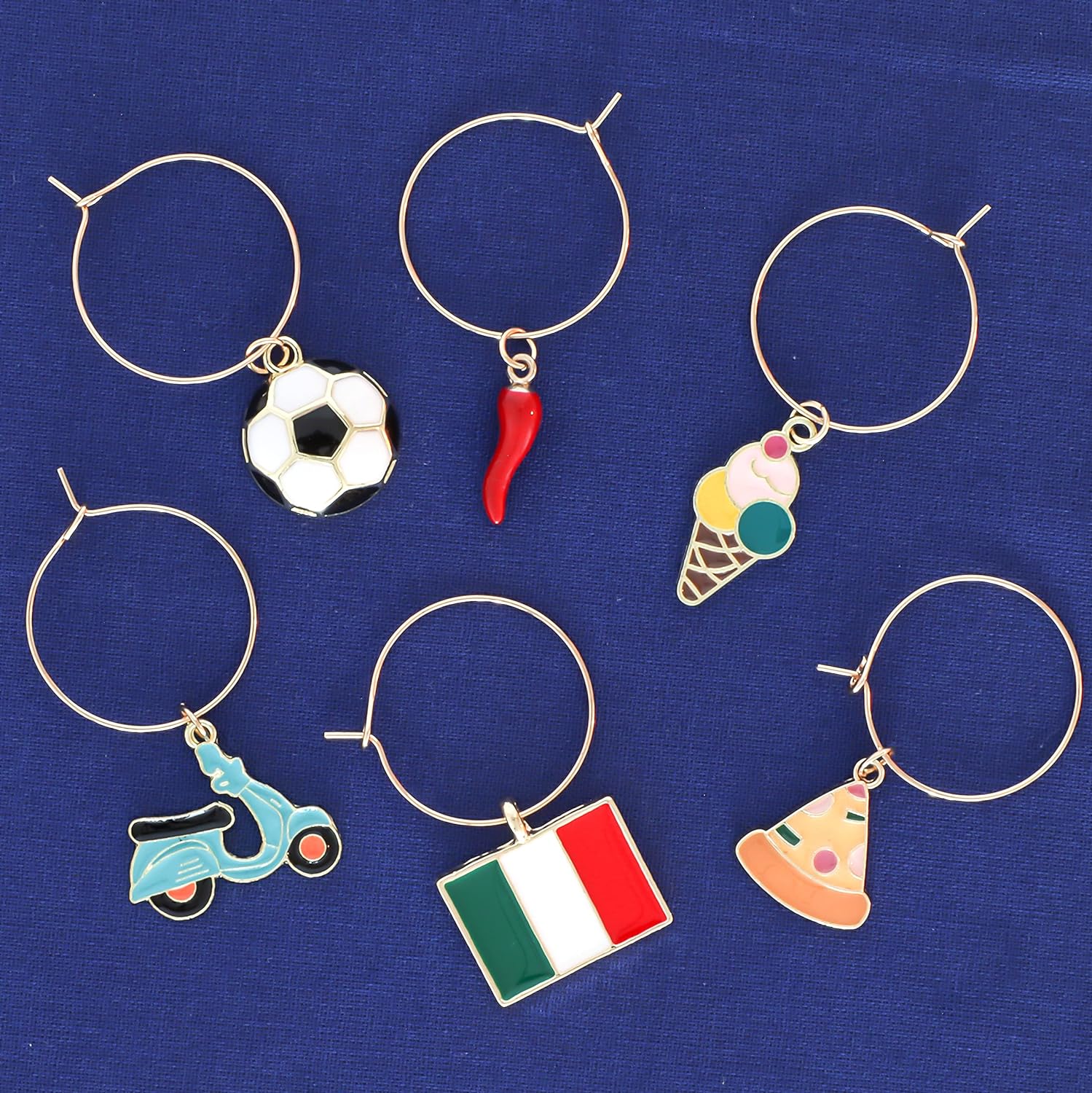 Italian Wine Charms set includes Italian Flag, Vespa, Soccer Ball, Gelato, Red Wine Glass, and Italian Horn on a blue surface