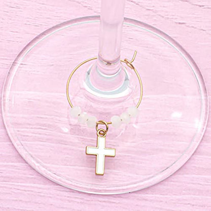 A Cross Wine Charm hooked on the glass.