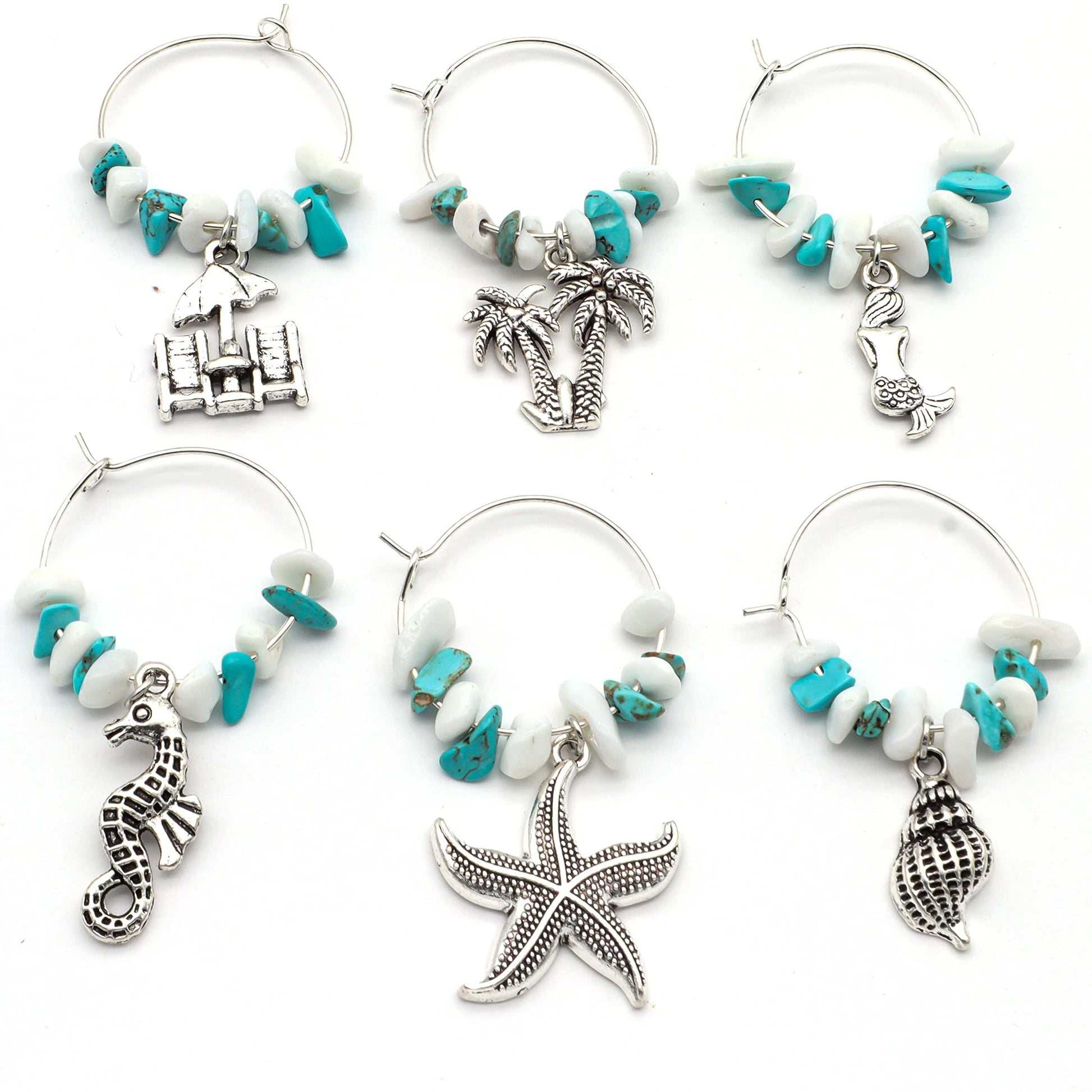 Ocean Wine Charms featuring turquoise colored palms, shells, seahorses, sea stars, and mermaids on a white surface.