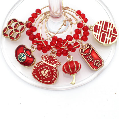 Red-Colored set of Chinese New Year Wine Charms hooked on wine glass.